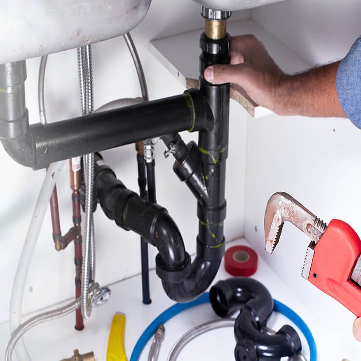 Plumber working under sink